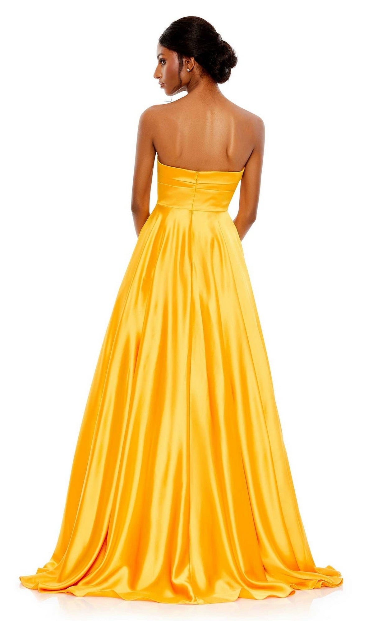 A woman faces away from the camera in the marigold yellow Long Formal Dress 67995 by Mac Duggal, a strapless satin ball gown with a sweetheart neckline, full floor-length skirt, and elegant A-line silhouette.